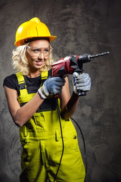 Attraktive Bauarbeiterin mit einem Bohrer in der Hand — Stockfoto