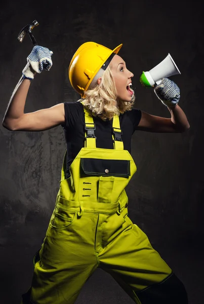 Mulher construtor atraente gritando através de megafone — Fotografia de Stock