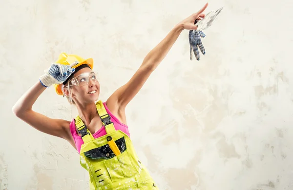 Female construction worker posing over white obsolete background — Stock Photo, Image