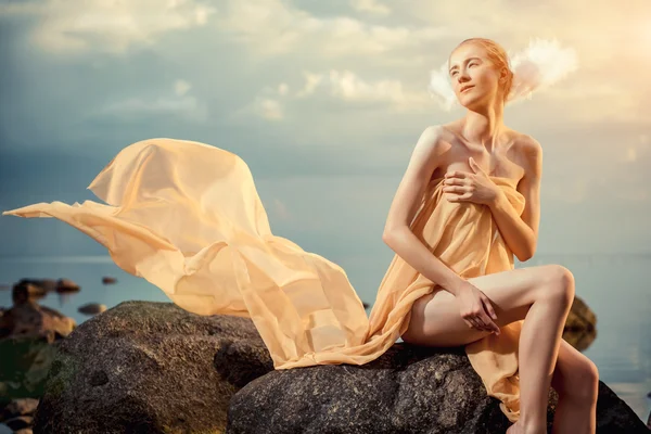 Young beautiful woman posing on the beach at sunset — Stock Photo, Image