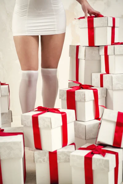 Jambes de femme et tas de boîtes-cadeaux — Photo