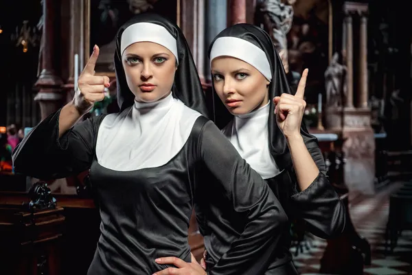 Привлекательные молодые монахини, позирующие в церкви — стоковое фото