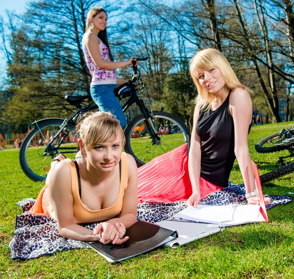 Tre attraktiva kvinnliga studenter avkopplande utomhus — Stockfoto
