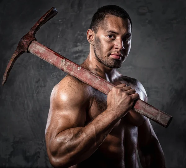 Homem muscular segurando picareta — Fotografia de Stock