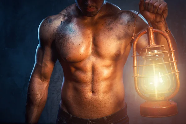 Hombre muscular sosteniendo la lámpara de aceite — Foto de Stock