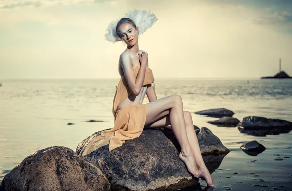 Joven hermosa mujer como cisne posando en la playa — Foto de Stock