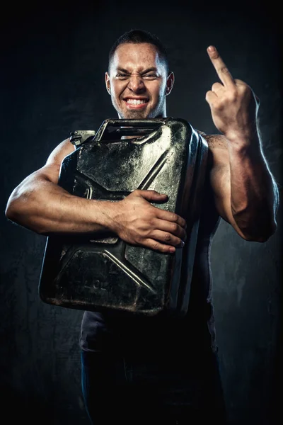 Man with metal fuel can showing middle finger — Stock Photo, Image