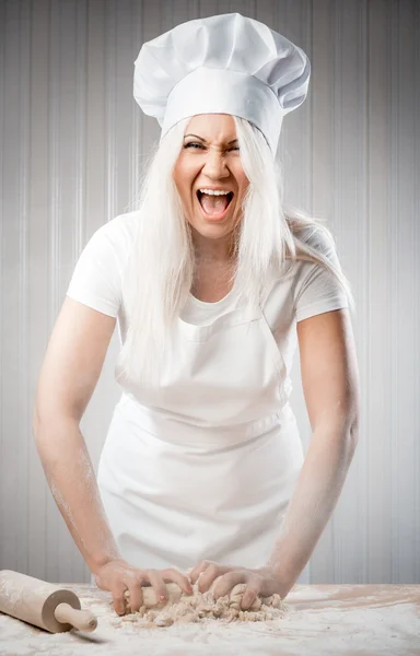 Angry and stressed out woman cook kneading dough — Stock Photo, Image