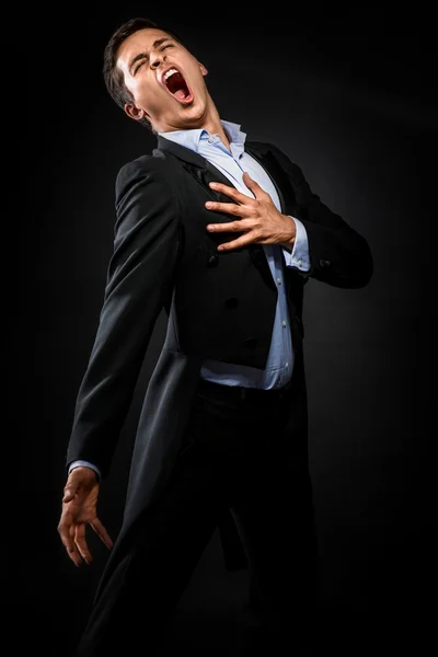 Man in elegant black jacket and blue shirt singing — Stock Photo, Image