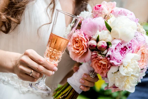 Beautiful bridal bouquet and glass of champagne — Stock Photo, Image