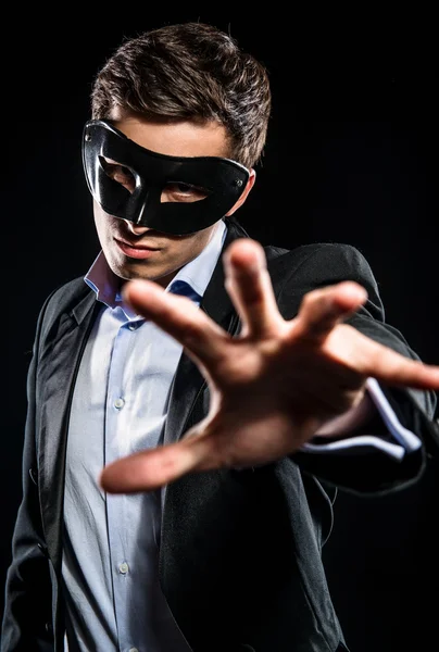 Elegante man dragen zwart masker poseren binnenshuis — Stockfoto