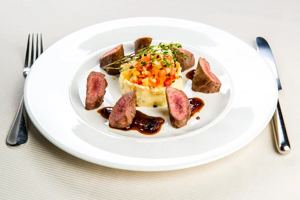 Beef and mashed potatoes decorated with vegetables — Stock Photo, Image