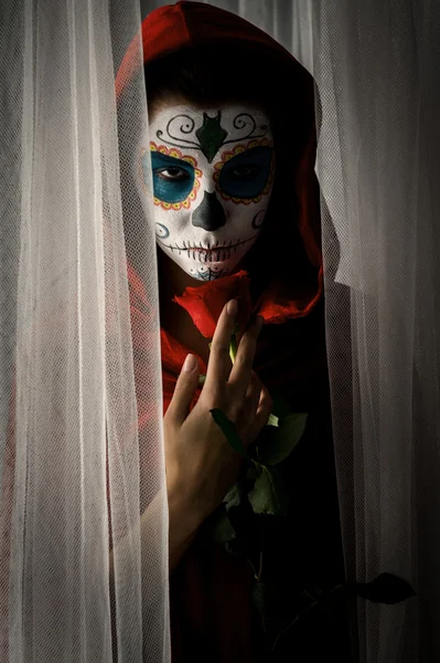 El día de la muchacha muerta con el maquillaje de la calavera de azúcar que sostiene la rosa roja — Foto de Stock