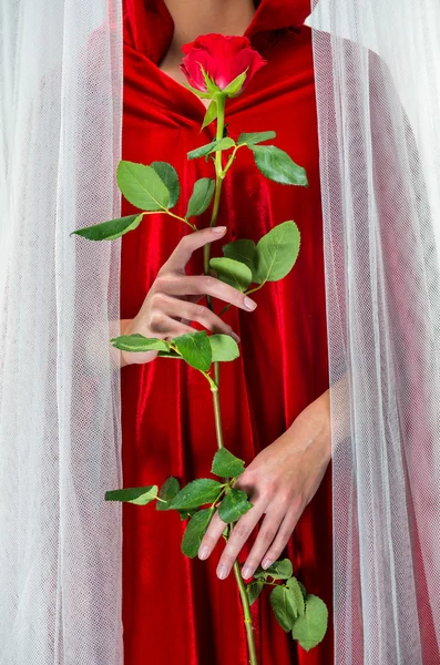 Mujer con manto rojo sosteniendo rosa roja — Foto de Stock