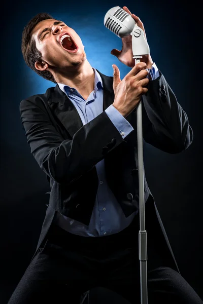 Człowiek w elegancki czarny płaszcz i śpiewu, niebieska koszula — Zdjęcie stockowe