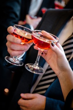 eller erkek ve kadın ile pembe şampanya bardakları tezahürat