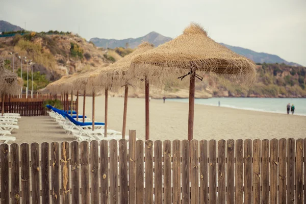 Parassóis e espreguiçadeiras vazias na praia de Nerja. Espanha — Fotografia de Stock