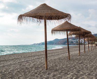 saman şemsiye boş sahilde. Nerja, İspanya