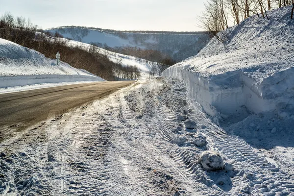 Snowdrifts e estrada rural — Fotografia de Stock