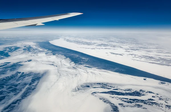 Wing of airplane flying above the Sea of Okhotsk — Stock Photo, Image