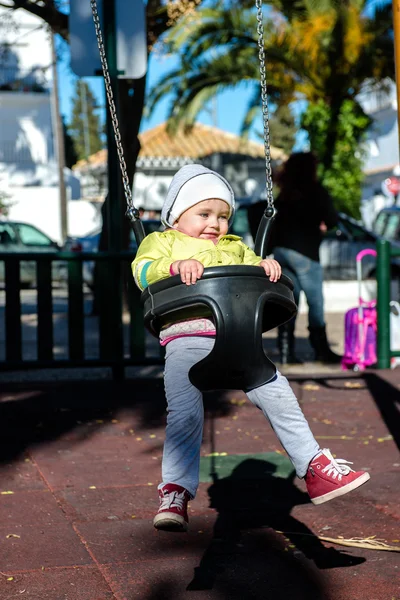 Bedårande liten tjej att ha kul på en gunga utomhus — Stockfoto