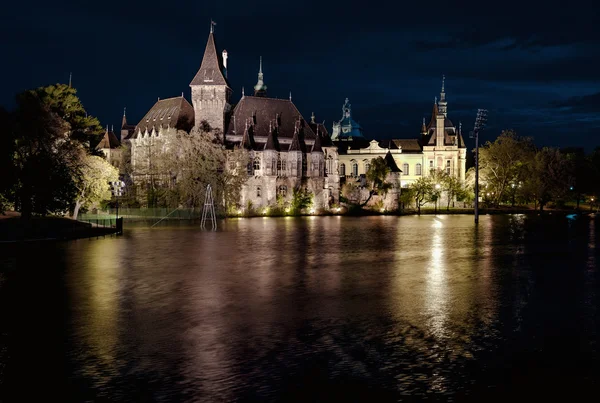Vista nocturna del castillo de Vajdahunyad desde la orilla del lago. Budapest, Hungar — Foto de Stock