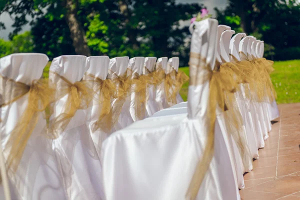Kahverengi yay açık havada beyaz düğün koltukları — Stok fotoğraf