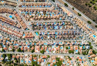 Pinar de Campoverde yerleşim bölgesi manzarası yukarıdan. İnsansız hava aracı manzaralı lüks yazlık villalar, güneşli bir yaz gününde havuz kenarındaki çatılar. Costa Blanca, Alicante ili, İspanya