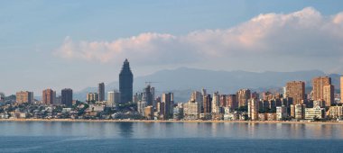 Benidorm şehrinin deniz kenarındaki uzak yatay görüntüsü. İspanya 'nın ünlü turistik tatil beldesi. Modern gökdelenler, Akdeniz. Alicante ili, Costa Blanca, İspanya