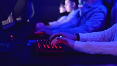 Yakın çekim yapan bir grup genç, siber kafe karanlık odada bilgisayar oyunları oynayarak bilgisayar başında oturuyorlar. E-spor çevrimiçi yarışma etkinliği, modern teknoloji, sanal oyun kavramına sahip gen z bağımlısı