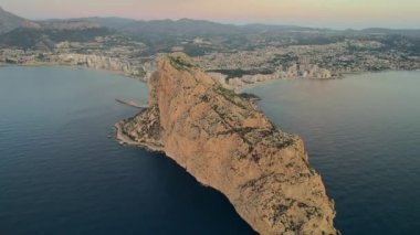 Hava görüntüsü kayalık dağın tepesi, İHA bakış açısı Penyal d 'Ifac Doğal Parkı ve Calpe şehir manzarası şafak vakti. Alicante vilayeti. İspanya. Seyahat ve turistik ünlü yerler konsepti