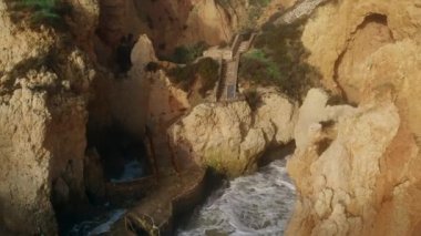 Uçan insansız hava aracı bakış açısı azgın okyanus ve Ponta da Piedade burnu. Kireçtaşı kıyı şeridi boyunca sarı uçurumlar, Lagos kasabası, Portekiz 'in en ünlü turistik merkezi.