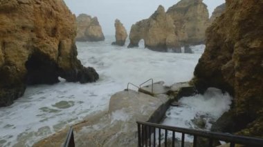 Uçan insansız hava aracı bakış açısı azgın okyanus ve Ponta da Piedade burnu. Kireçtaşı kıyı şeridi boyunca sarı uçurumlar, Lagos kasabası, Portekiz 'in en ünlü turistik merkezi.