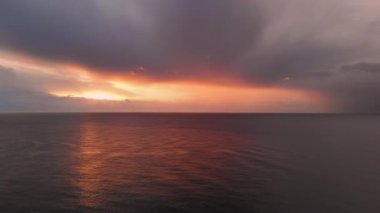 Picturesque sunrise over calm Mediterranean Sea. Bright colourful sunset with gloomy cloudy sky over the smooth ocean, horizon over water. Beauty in nature concept. Spain