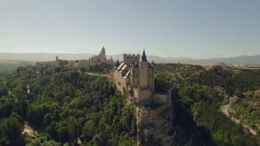 İspanya 'nın Kastilya ve Leon kentindeki güneşli bir günde Segovia Ortaçağ Kalesi' nden Alcazar 'ın hava aracı bakış açısı mavi gökyüzüne karşıdır. Kale, UNESCO 'nun bir Dünya Mirası Alanı