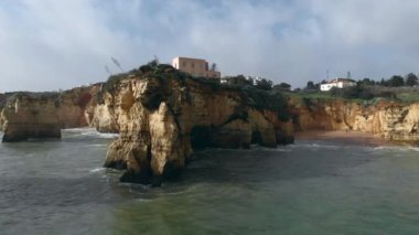 Panoramik hava manzarası, Praia dos Estudantes 'in kireçtaşı uçurumları, Lagos, Algarve' deki öğrenci plajı. Bulutlu güneşli bir günde güzel kayalar manzarası. Portekiz