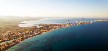 Hava resimli panoramik yatay görüntü, İHA bakış açısı La Manga del Mar Menor şehir manzarası ve deniz kenarındaki Turkuaz Akdeniz manzarası. Murcia, İspanya. Seyahat ve tatil kavramı