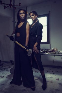 İki kadın içeride poz verirken şık moda kıyafetleri giyer. Moda ve güzellik konsepti