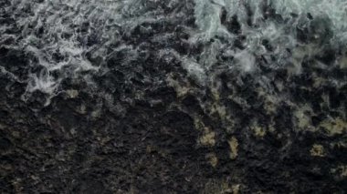 Atlantik Okyanusu 'nun hava manzarası dalgaları, kayalık plaj, siyah volkanik taşlar, doğrudan manzaranın üzerinde turkuaz su bulunan körfez, doğa arka planı. İnsan yok. Lanzarote, Kanarya Adaları, Haria. İspanya