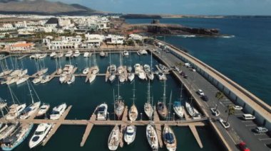 Drone bakış açısı, hava çekimi, lüks yatlar, botlar, Lanzarote Adası limanında deniz gemileri, güneşli bir günde Atlantik Okyanusu ile çevrili, mavi gökyüzü, resim manzarası. Kanaryalar. İspanya