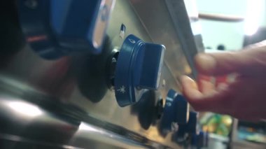 Tanımlanamayan aşçı erkek elleri restoranın mutfağında gaz sobasını yakar, manzarayı kapatır. Yemek pişirme, profesyonel mutfak aletleri reklam konsepti