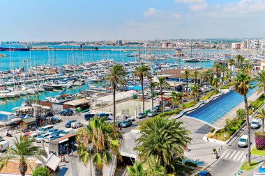 Aerial shot Torrevieja puerto harbour view from above, scenic palm-tree lined seafront, nautical vessels moored on Mediterranean Sea bay. Costa Blanca. Province of Alicante. Spain. Travel concept