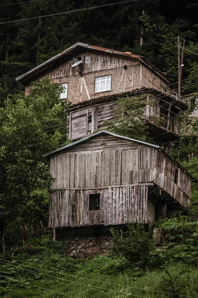 Cabanas de madeira e uma casa em uma colina — Fotografia de Stock