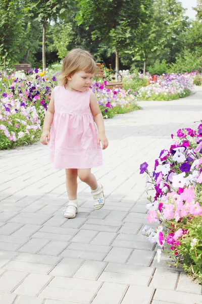 Meisje wandelt op een steegje bloemen — Stockfoto