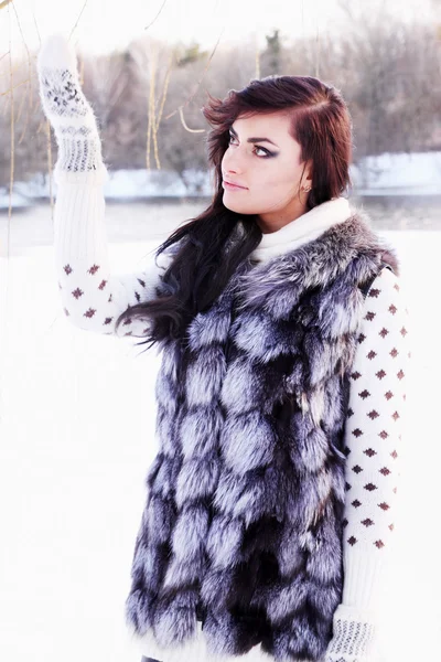 Dziewczyna w kamizelka futro łapie śnieg — Zdjęcie stockowe