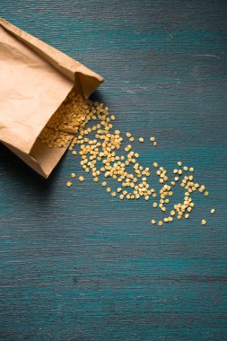 Ahşap zemin üzerinde kuru biber tohumları olan kağıt torba.