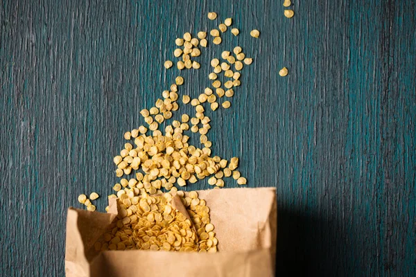 Ahşap zemin üzerinde kuru biber tohumları olan kağıt torba.