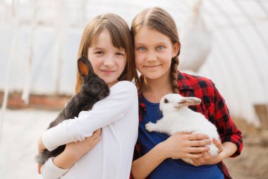 Ellerinde tavşan tutan iki kız. Paskalya konsepti