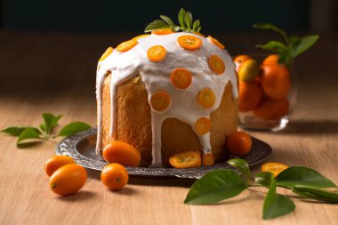 Paskalya pastası ve ahşap arka planda sulu kumkatlarla dolu bir hayat.