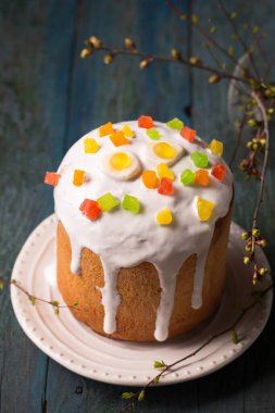 Tahta arka planda yumurta şeklinde jöleli şekerlemelerle süslenmiş Paskalya pastaları. Boşluğu kopyala.